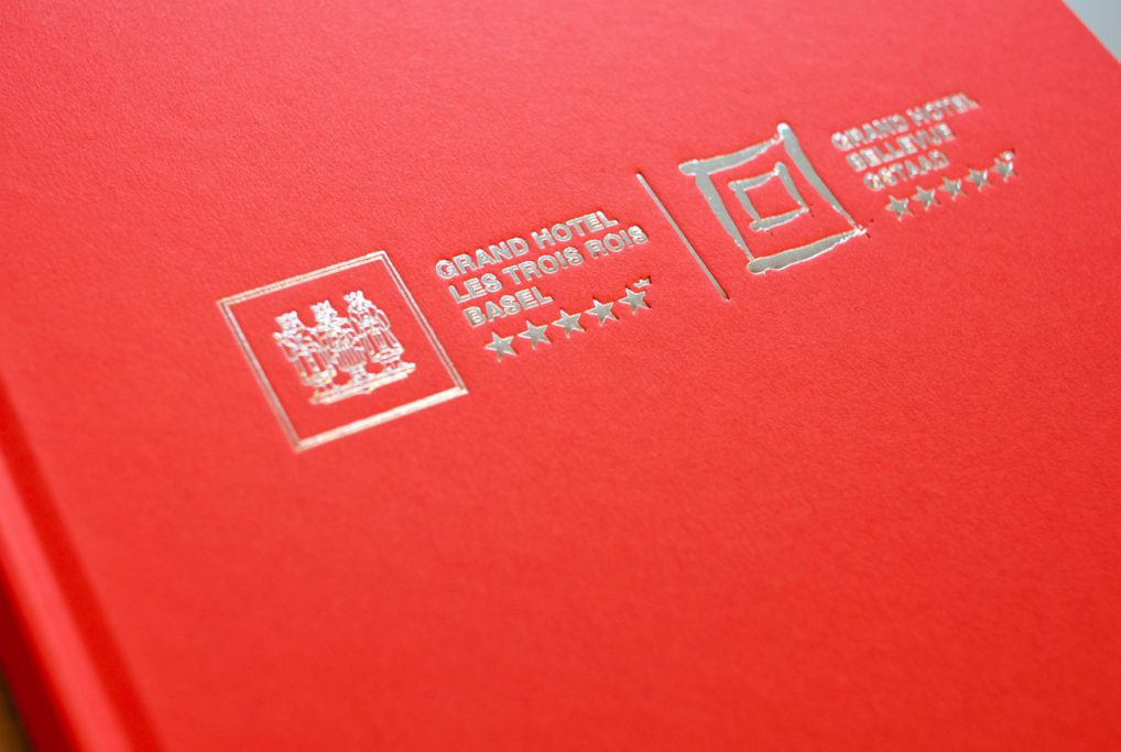 Red book cover with embossed logos and text in English and another script.
