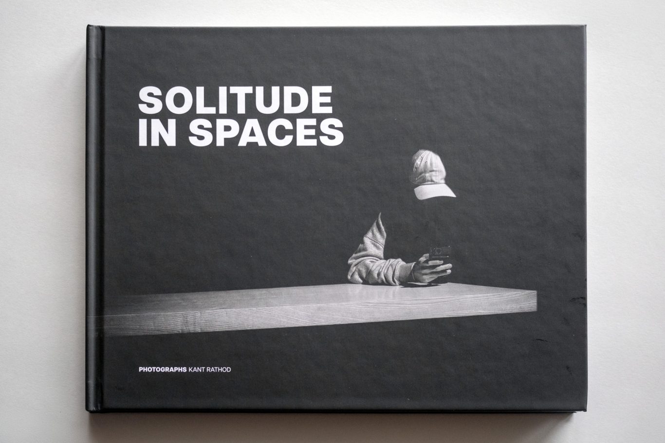 A black book titled "Solitude in Spaces" featuring a minimalist sculpture on the cover.