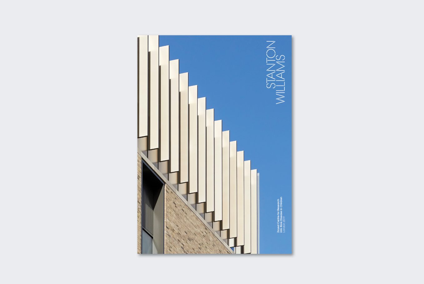 Modern building facade with angular white panels against a clear blue sky.